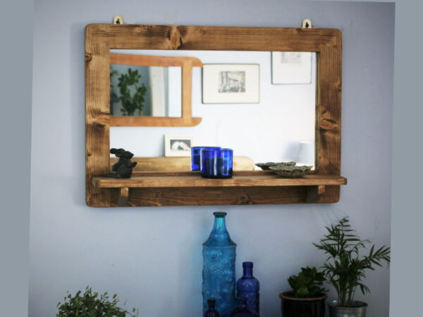Wooden mirror with shelf seen from front.
