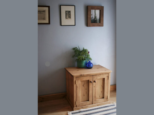 Wooden sideboard cabinet long view with blue glass ornaments on the top.