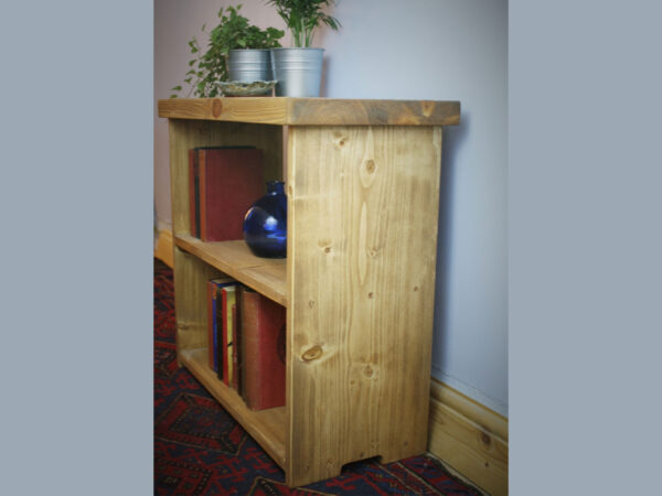 Small rustic bookcase in natural sustainable wood, side view.