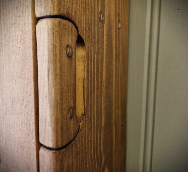 Small wooden bathroom cabinet with a minimalist integrated wooden handle.