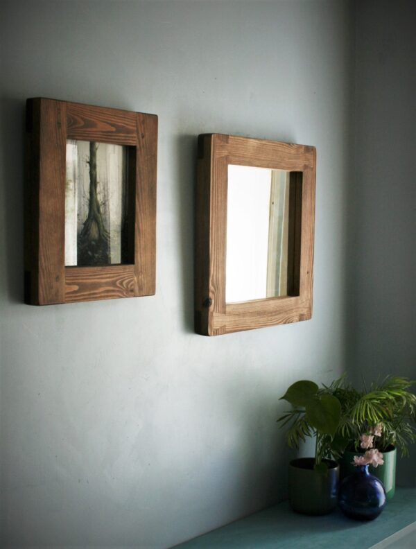 Square mirror with a natural wooden frame, long side view.