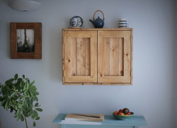 Wooden kitchen cabinet in rustic cottage style, front view.