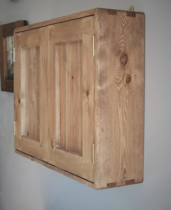 Wooden kitchen cabinet in rustic cottage style, side view.