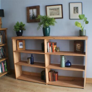 Wide wooden bookshelves in chunky rustic natural wood, handmade in Somerset UK. Long view.