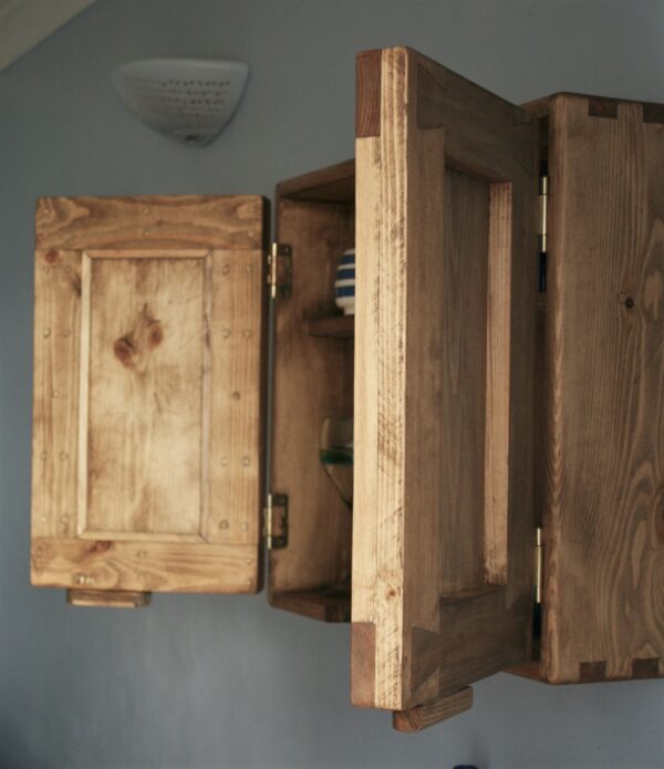 Bathroom cabinet without mirror, chunky rustic double wooden doors open; side view.