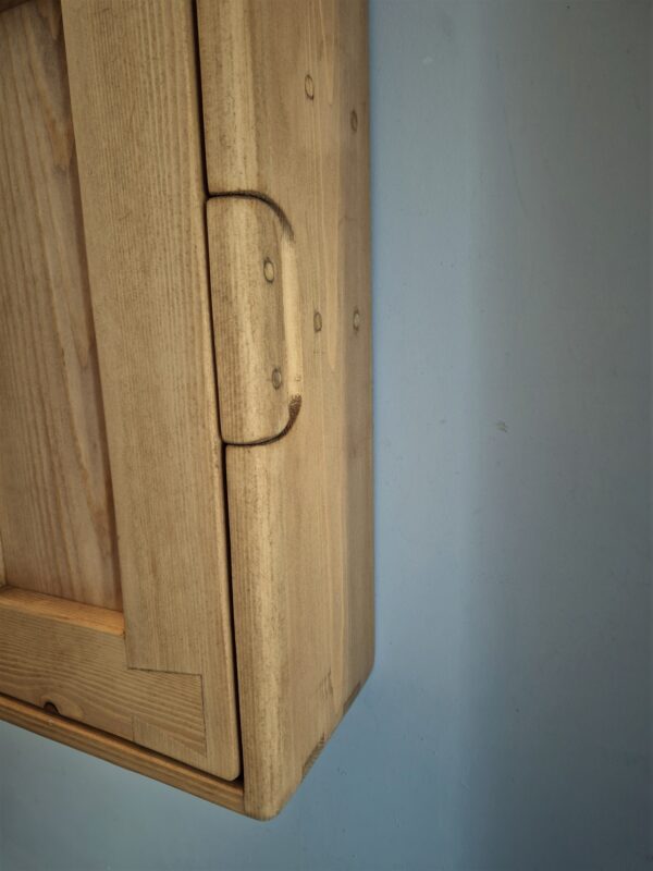Slim bathroom wall cabinet detail of hidden handle.