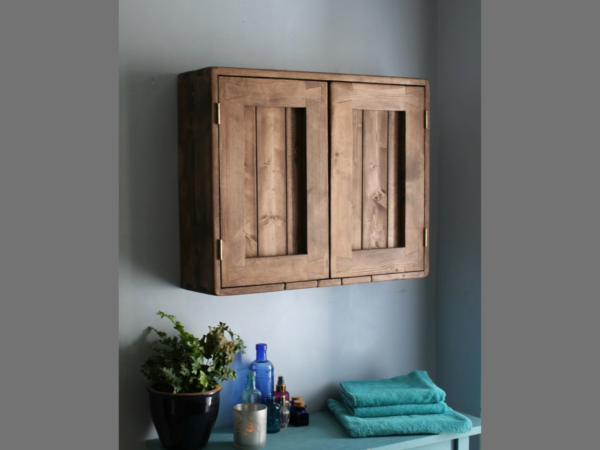 Farmhouse bathroom cabinet in natural wood with houseplant, towels and blue glass. Handmade in Somerset UK.