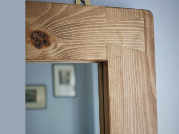 Large mirror with shelf and chunky iron hooks in our modern rustic style. Detail of wooden frame.
