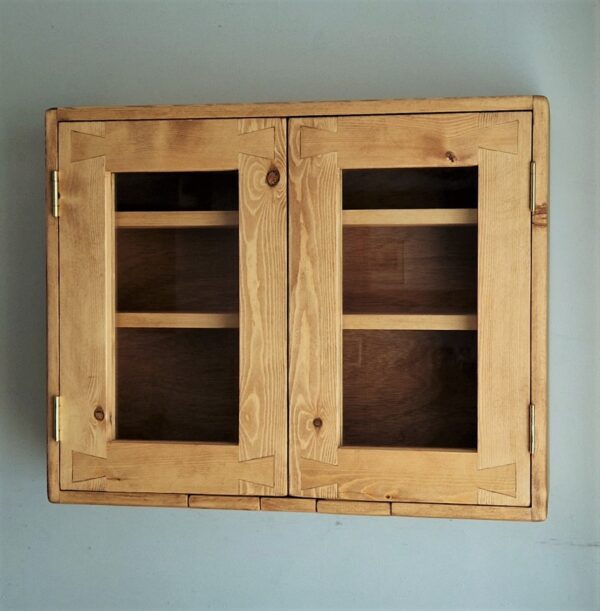 Glazed display kitchen cabinet in natural wood in the modern rustic style.