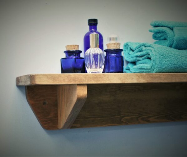 Small wooden bathroom shelf in chunky natural wood. For cosmetics, plants and towels. Edge view, handmade in Somerset UK
