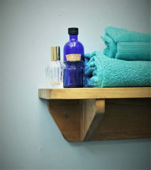 Small wooden bathroom shelf in chunky natural wood. For cosmetics, plants and towels. Close view, handmade in Somerset UK