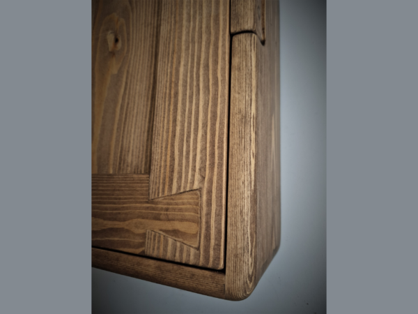 Dovetail detail on wooden kitchen cabinet door.