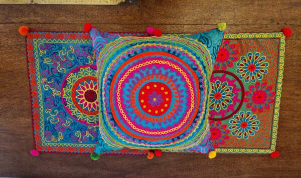 Colourful embroidered cushion cover, abstract mandala pattern in pink, blue and green. Bohemian rustic homeware from Somerset.