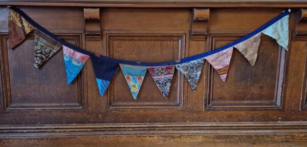 Colourful silk bunting handmade from recycled sari fabric. Portable decorative garlands for boho rustic home, garden party, camping festival.