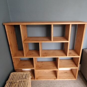 Non uniform bookcase and room divider in chunky natural wood, deep shelves, uneven modern rustic bookshelf, custom handmade in Somerset UK. Front view.