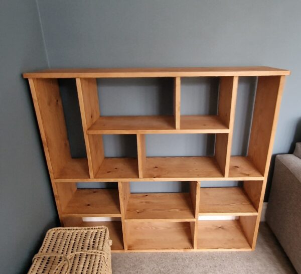 Non uniform bookcase and room divider in chunky natural wood, deep shelves, uneven modern rustic bookshelf, custom handmade in Somerset UK. Front view.