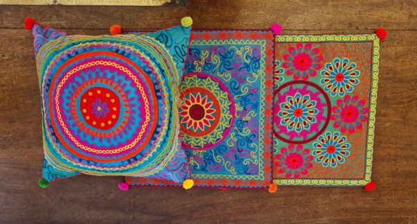 Colourful applique embroidered cushion cover, bright pattern in hippy jewel tones - ethical bohemian rustic homeware from Marc Wood Furniture in Somerset.