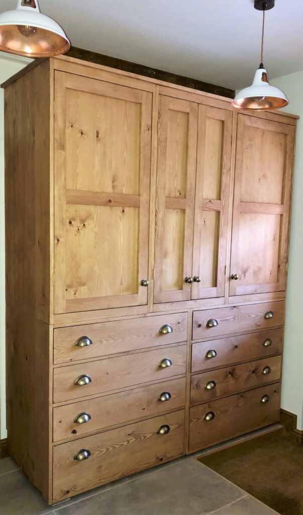 Rustic bedroom wardrobe with triple doors and lower cup handle drawers in natural sustainable wood, handmade to order in Somerset UK