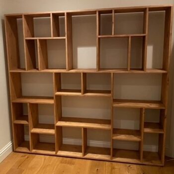 Large asymmetrical wooden bookshelf with open geometric, uneven shelving, modern rustic wooden bookcase from Somerset UK